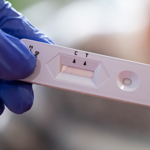 Eine Altenpflegerin hält einen Antigen-Corona-Schnelltest in der Hand.