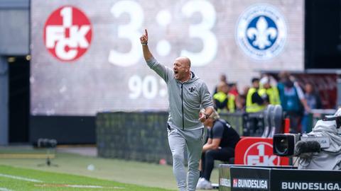 Torsten Lieberknecht gestikuliert, hinter ihm zeigt die Anzeigentafel das 3:3 der Lilien in Kaiserslautern an.