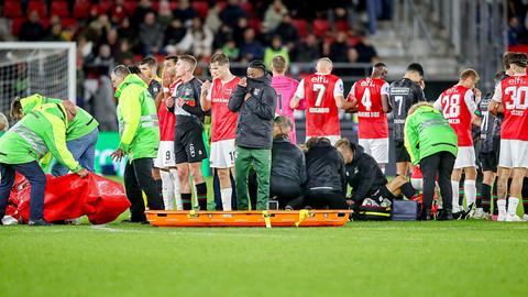 Mitspieler und Gegner stehen um Bas Dost herum, der auf dem Feld behandelt wird.