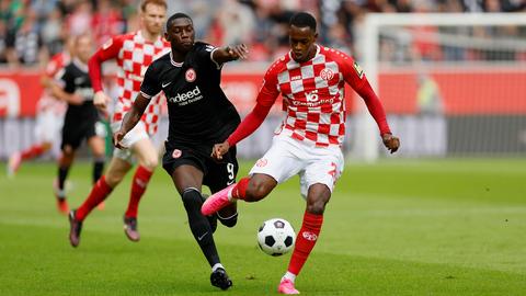 Das Bild zeigt Kolo Muani im Duell gegen Edimilson Fernandes von Mainz 05.