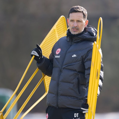 Eintracht-Trainer Dino Toppmöller beim Training. Er stellt Figuren auf.