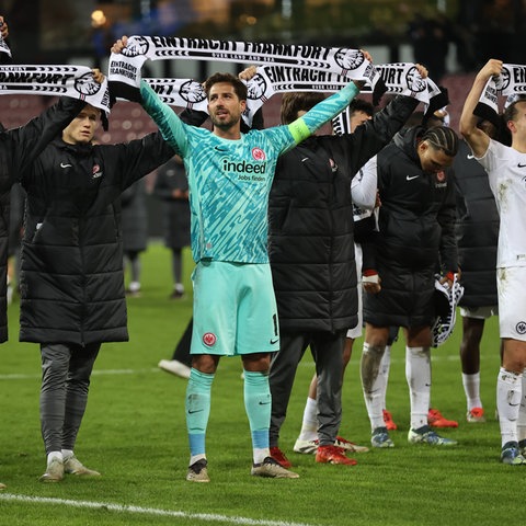 SGE-Spieler um Kevin Trapp (M) feiern nach dem Sieg in Midtjylland mit den Fans