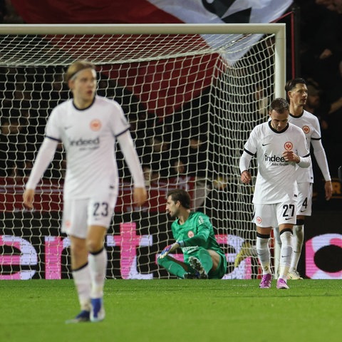 Die Spieler von Eintracht Frankfurt mit gesenktem Kopf