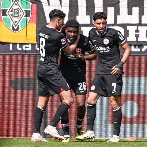 Eric Dina-Ebimbe ( 26, Eintracht Frankfurt) jubelt nach dem Tor zum 1:1 mit Fares Chaibi und Omar Marmoush.