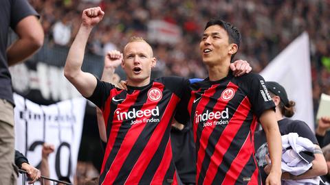 Sebastian Rode und Makoto Hasebe auf dem Zaun bei den Fans