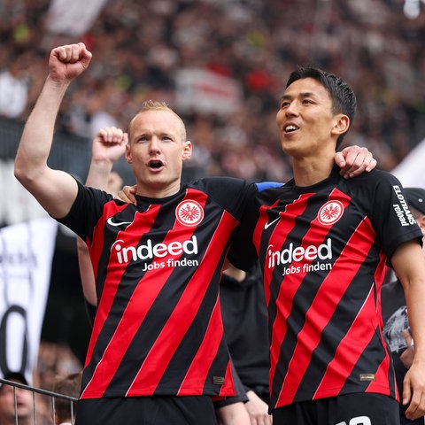 Sebastian Rode und Makoto Hasebe auf dem Zaun bei den Fans