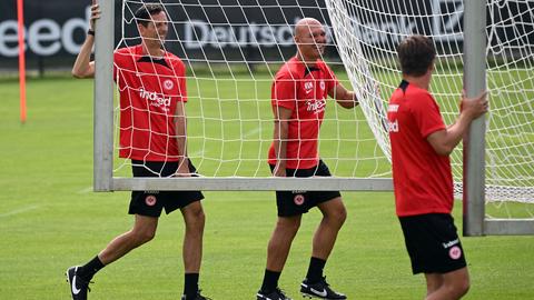 Das Trainerteam um Dino Toppmöller trägt ein Tor über den Rasen