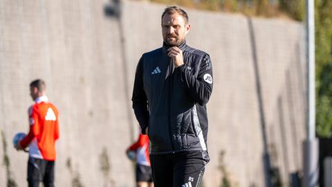 Union-Trainer Bo Svensson zieht den Reißverschluss der Trainingsjacke hoch.